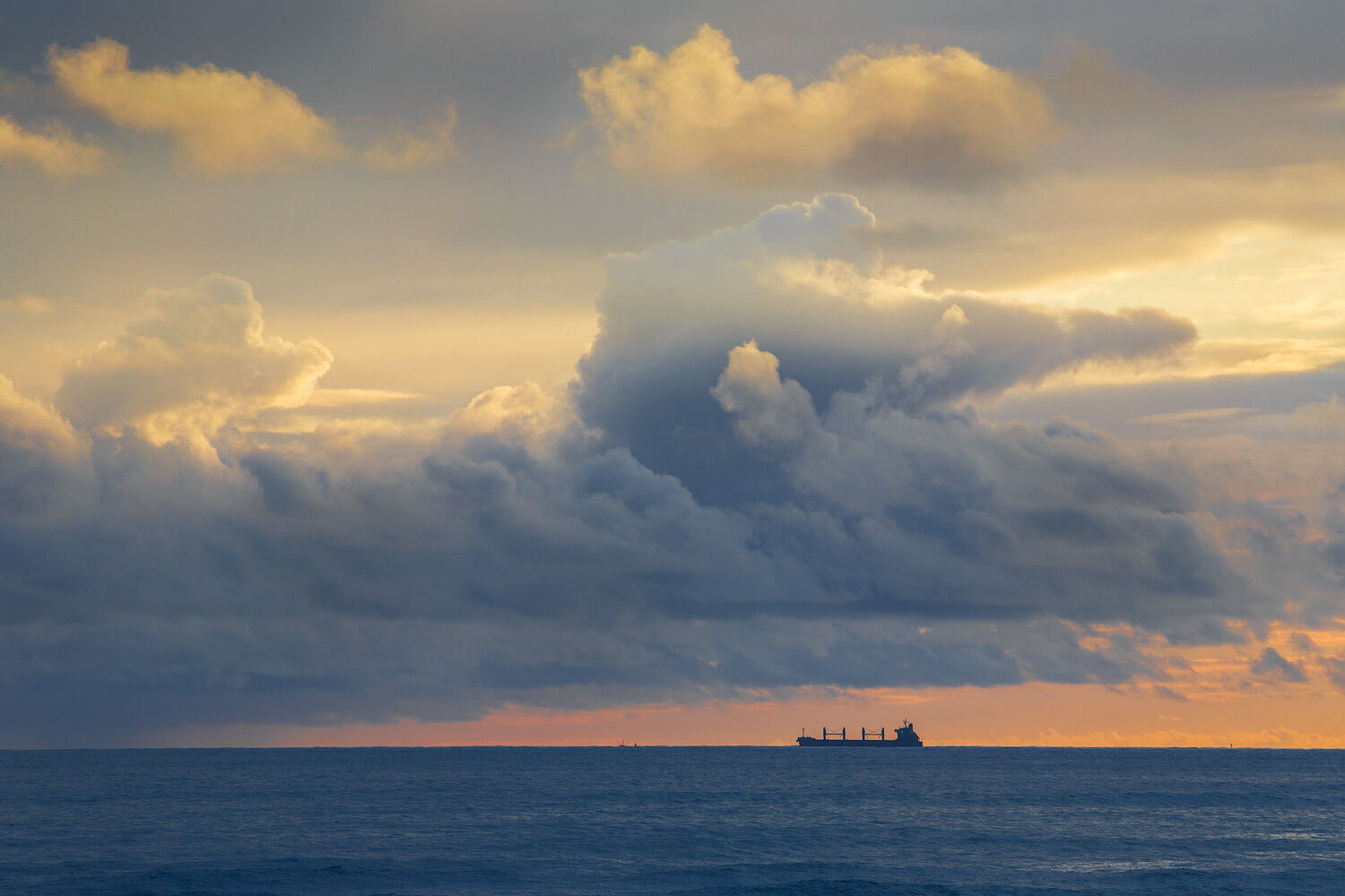 Large cargo carrier heading into the darkness of a storm and nightfall as the sunsets on the Oregon coast.