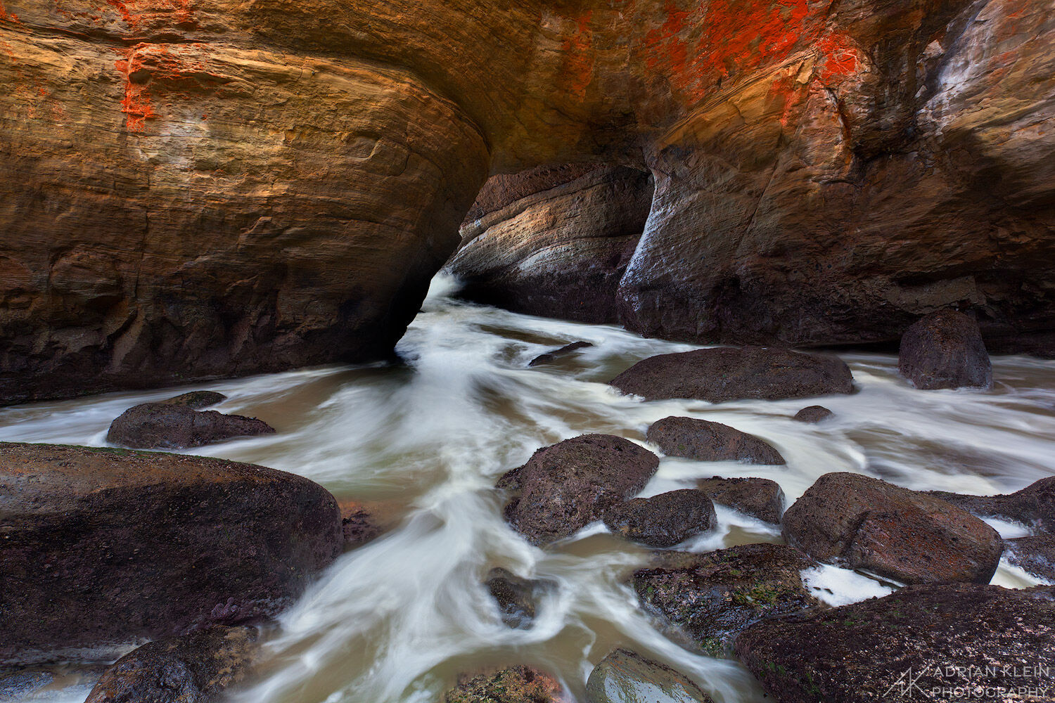 Standing inside the Devil's Cauldron at the Devil's Punchbowl State Park along the Central Oregon Coast. Waves roll in and out...