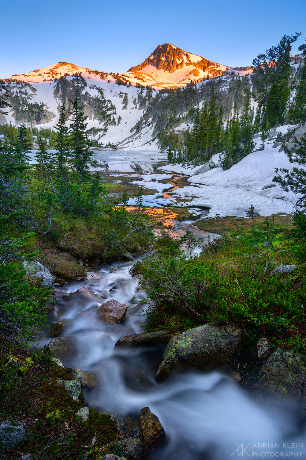 The winding curves of a stream flowing into Mirror Lake with Eagle Cap Mountain in the background. During the summer snow melt...