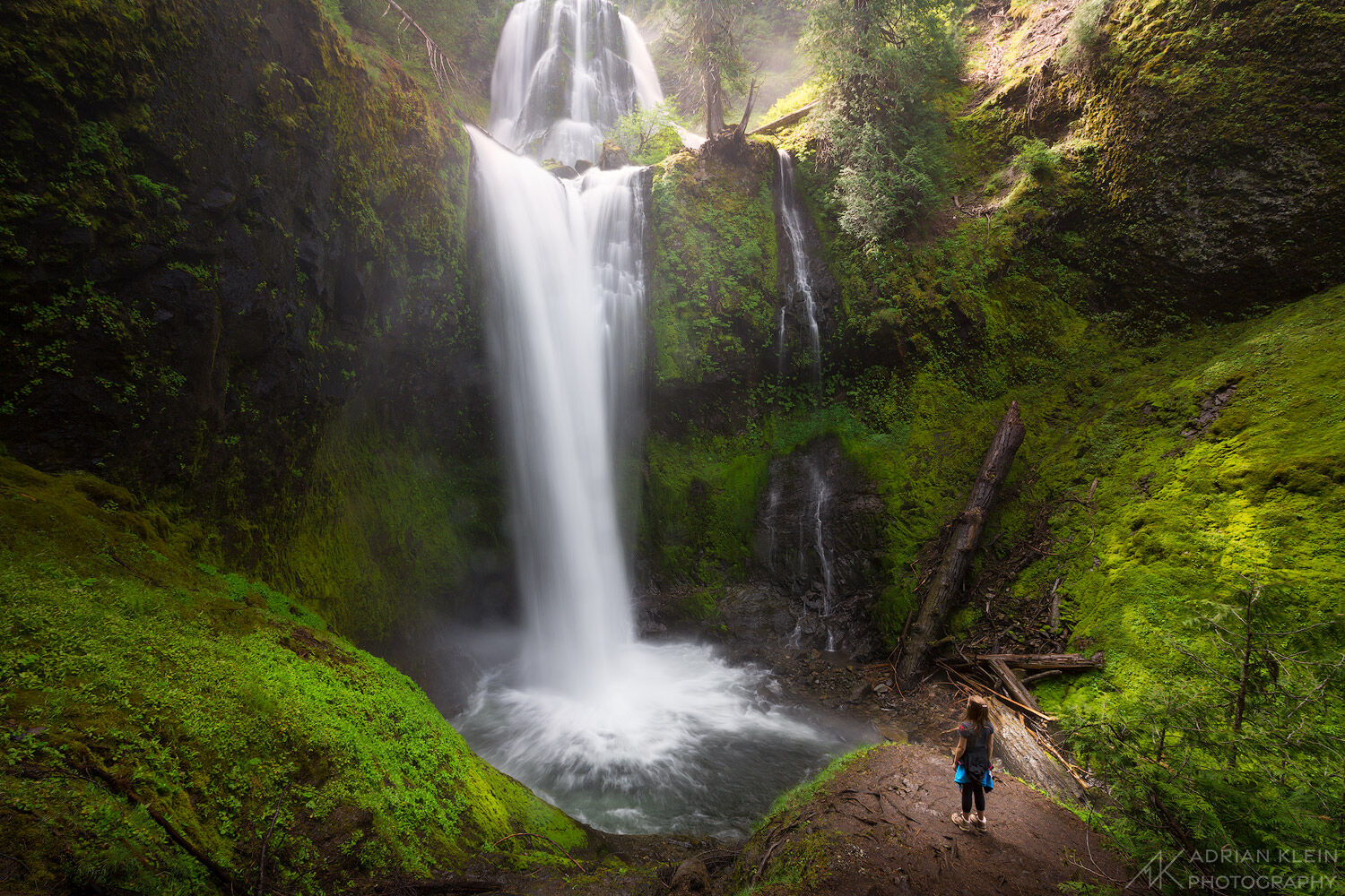 My daughter standing admiring a large waterfall in Washington.