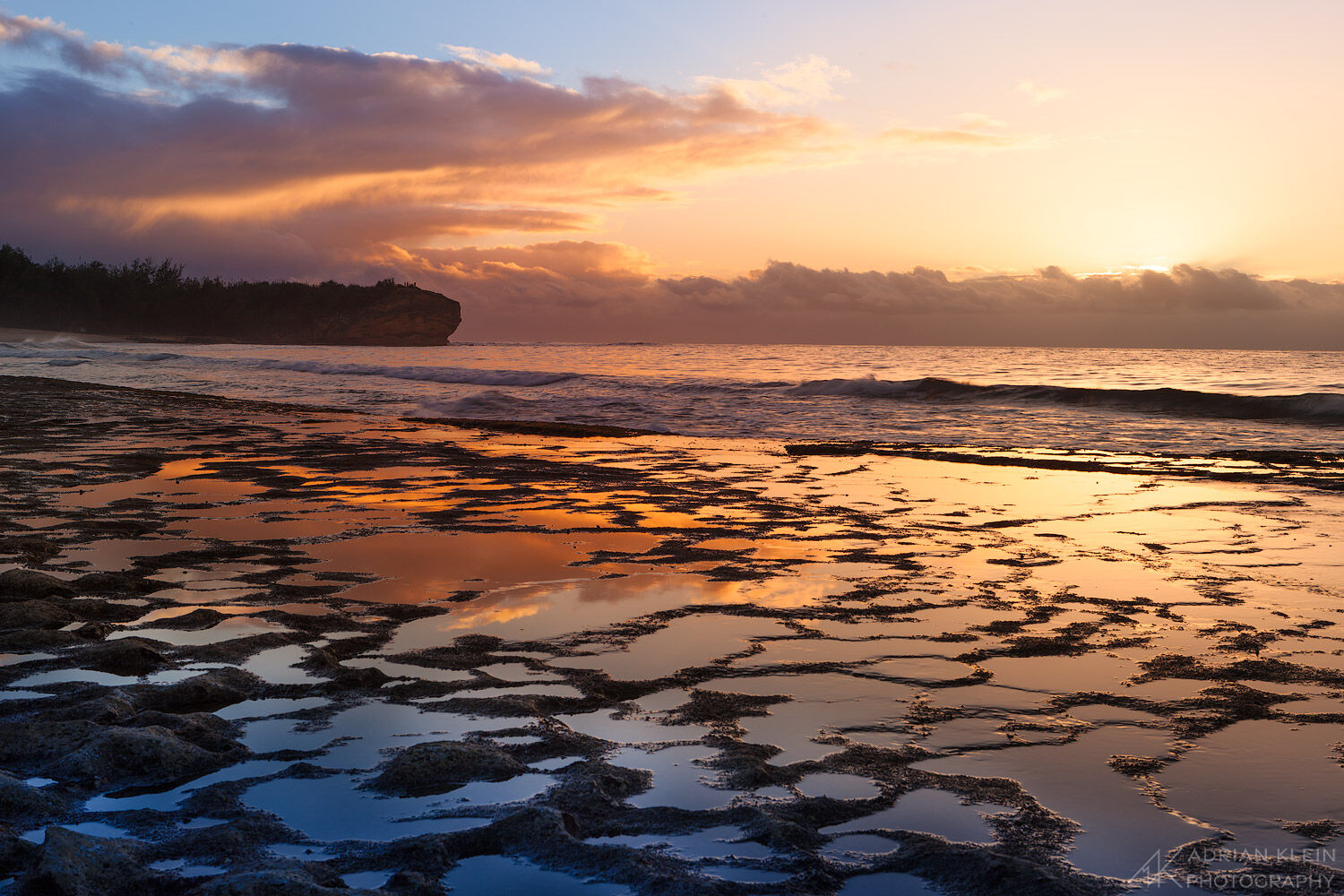Pools of ocean water along the south shore of Kauai at Shipwreck Beach at sunrise.