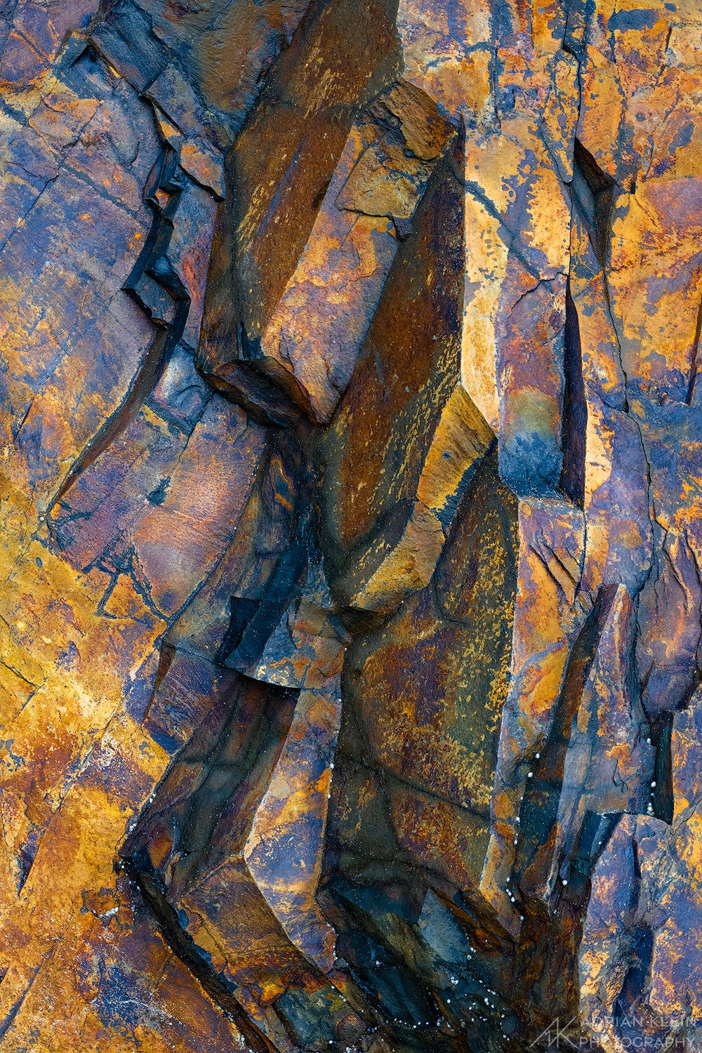 A large rock wall showing some vibrant copper and orange colors along the Oregon Coast. Limited Edition of 50.