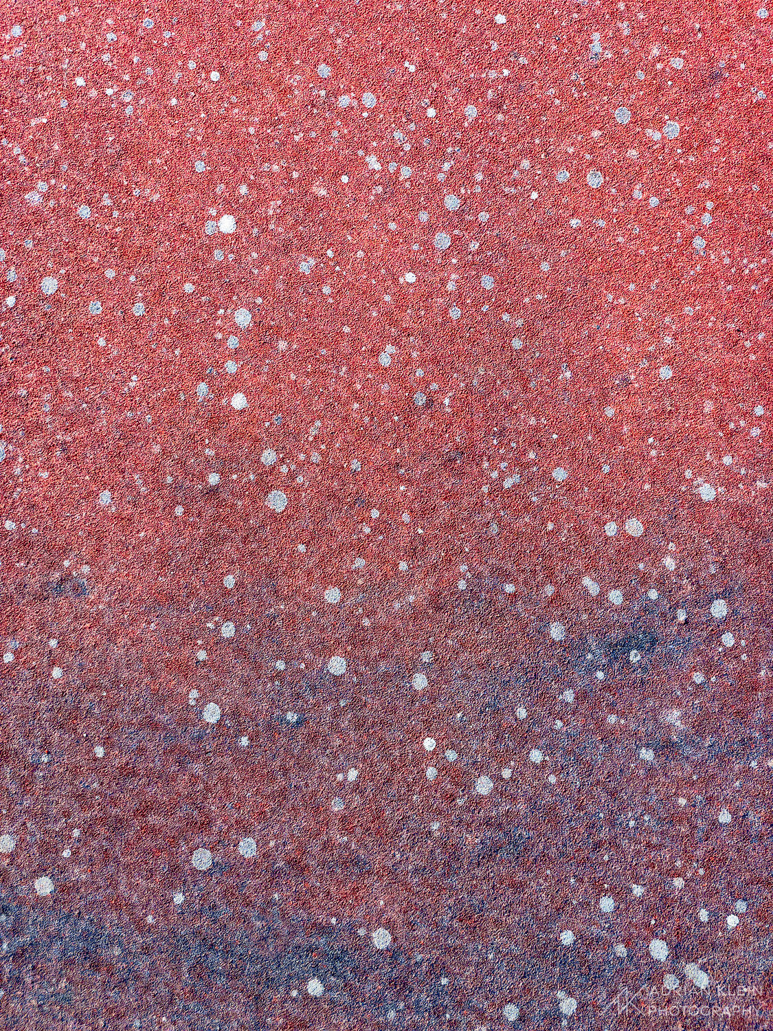 Surface of tennis court bringing out the red, white and blue from both the natural surface and the slow deterioration with mold...