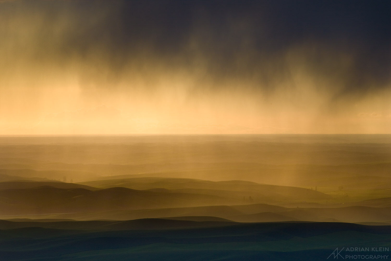 A quick low hanging storm rolls through the Palouse Hills at sunset.
