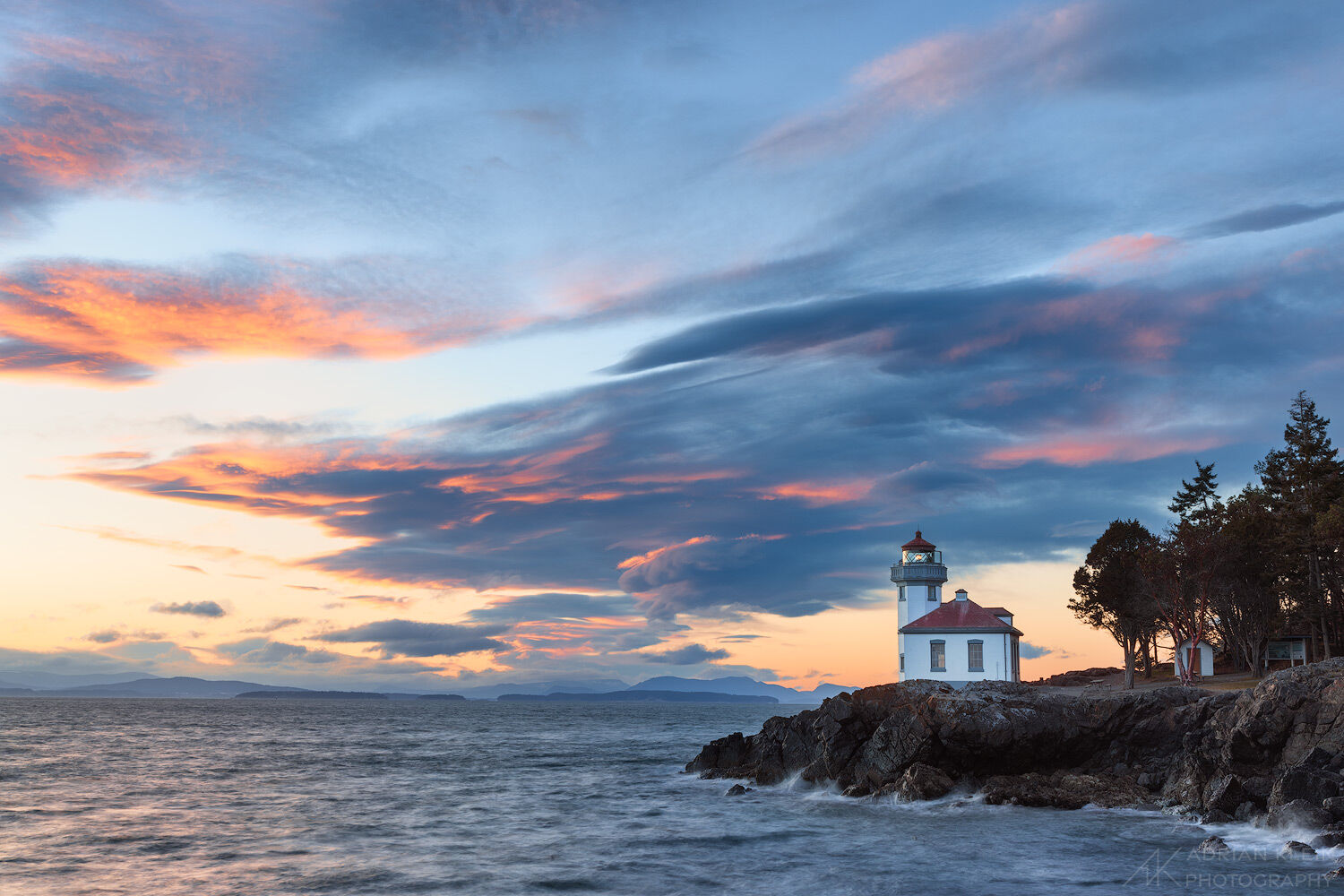 Lighthouse as the sunset sky glows at Lime Kiln Point State Park in Washington San Juan Islands