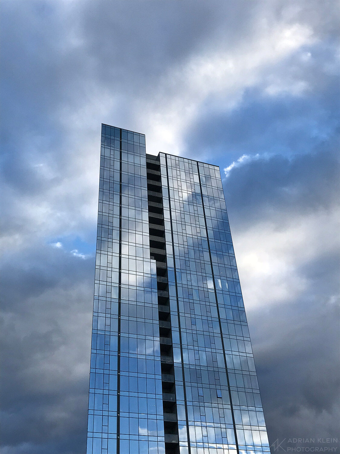 Glass building in NW Portland reflecting the dramatic sky